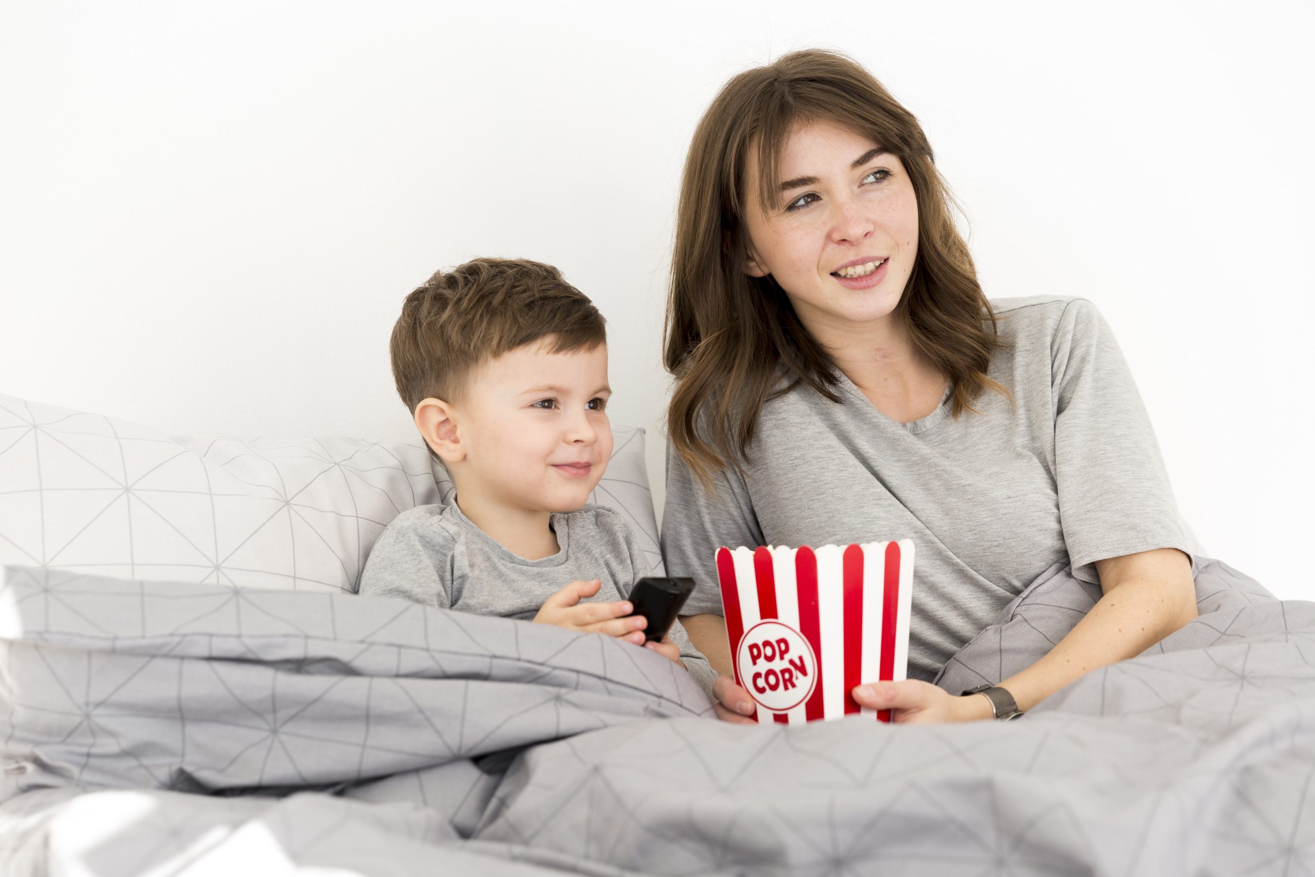 Na imagem, mãe e filho assistem juntos a um filme.