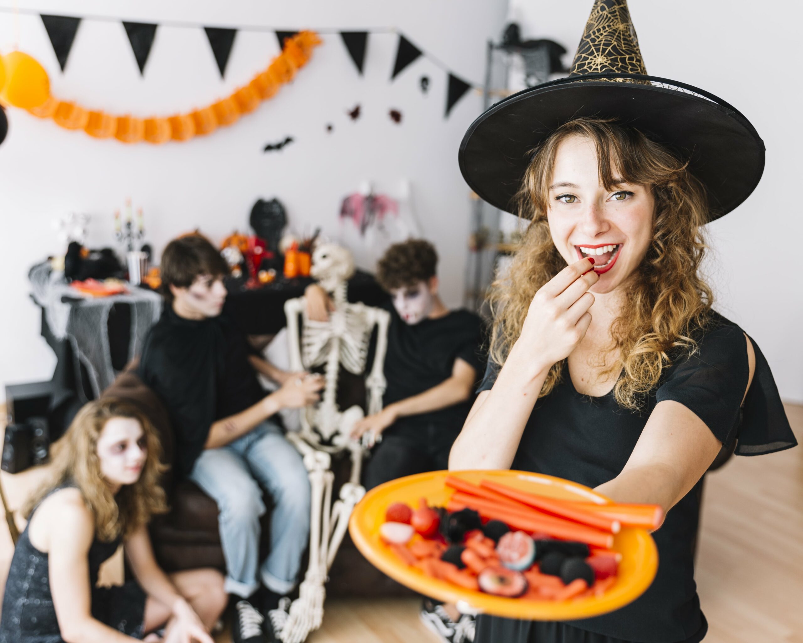 Festa de Halloween decorada com abóboras, teias de aranha artificiais e comidas temáticas assustadoras.