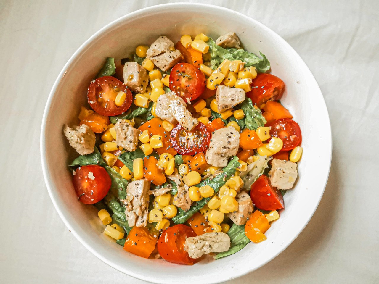 Salada fria de atum com batatas, folhas verdes e molho cítrico servida em travessa